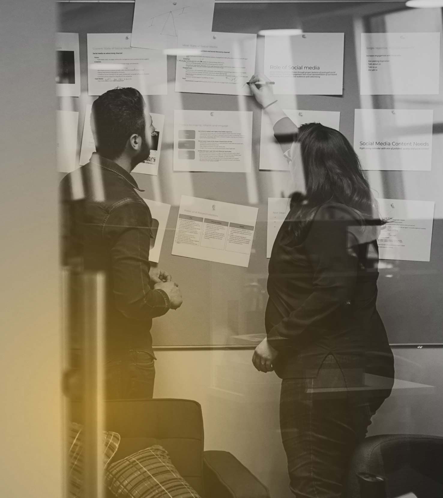 Photograph of two people working on a vision board.